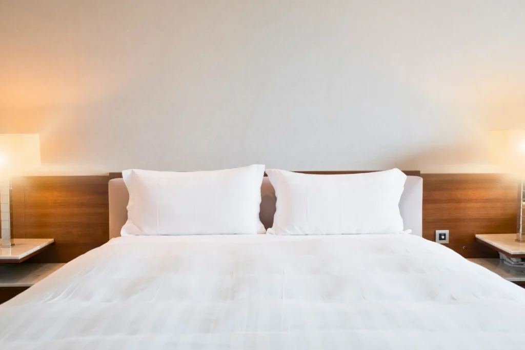 Bed in a hotel room, with warm lighting