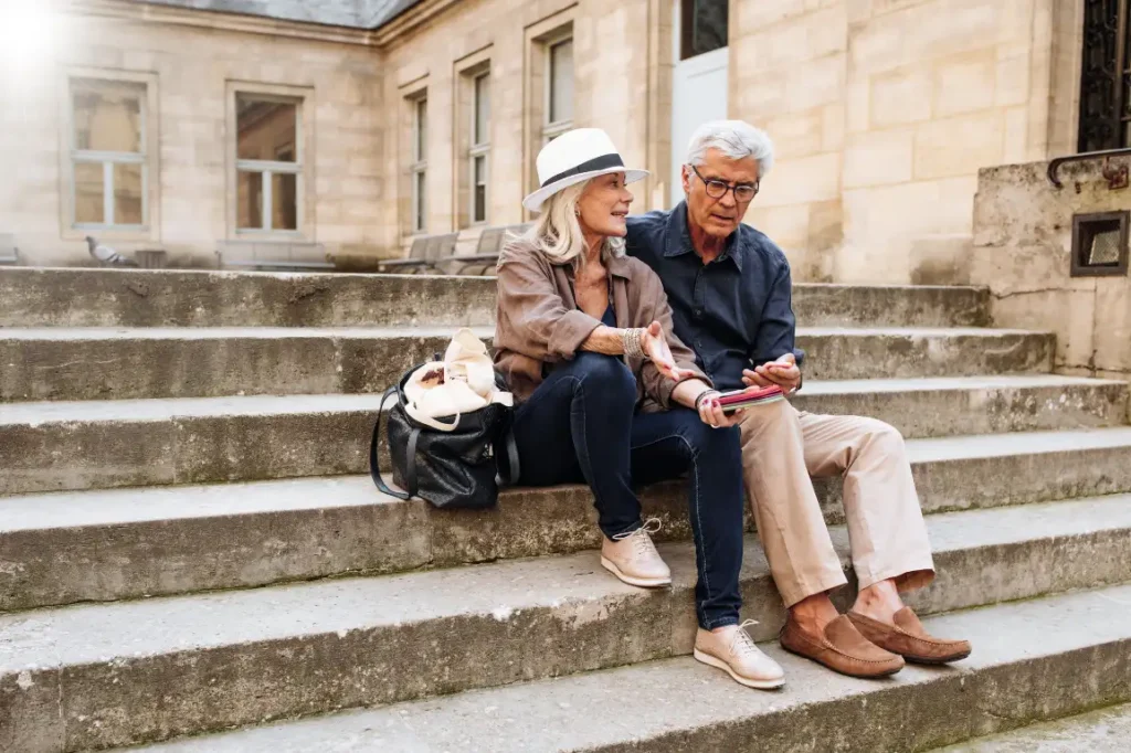 Senior couple sitting on steps in Europe
