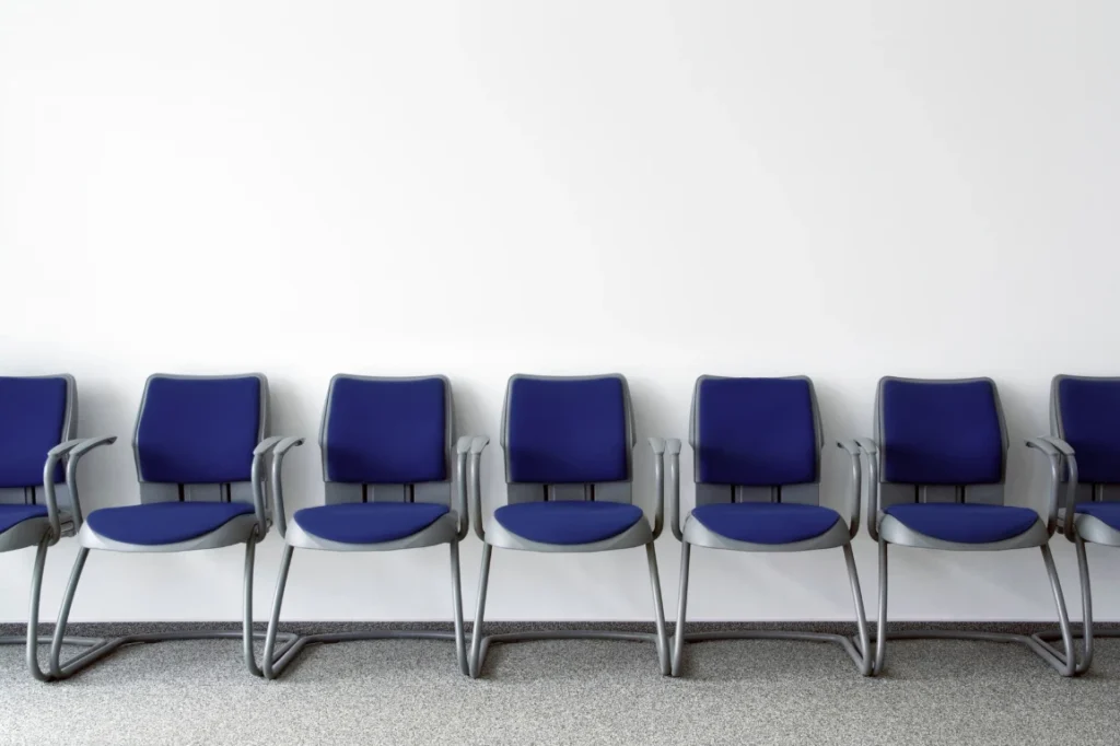 Dark blue chairs lined up in a clean waiting room.