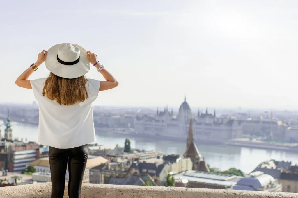 Woman tourist in Budapest, looking out over the Parliament. 
