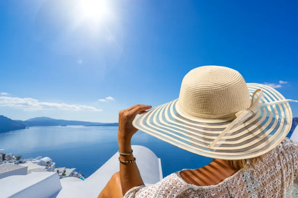 Woman in a sun hat on a patio in Greece