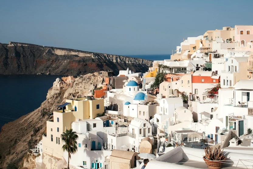 The white and pastel buildings of Santorini, with cliffs in the distance.