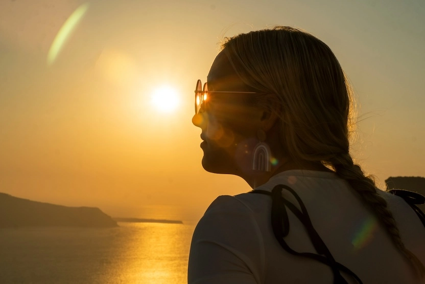 A woman watching the Santorini sunset.