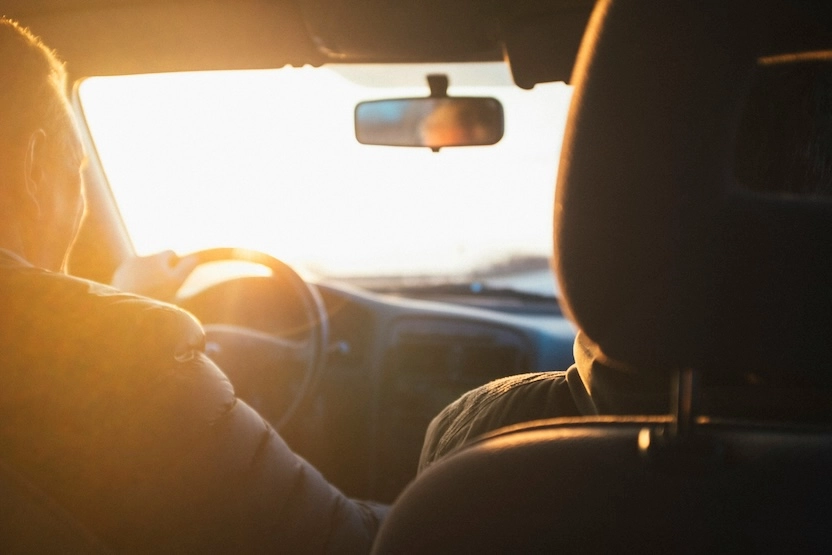 Tourists driving a car in Europe at sunset.