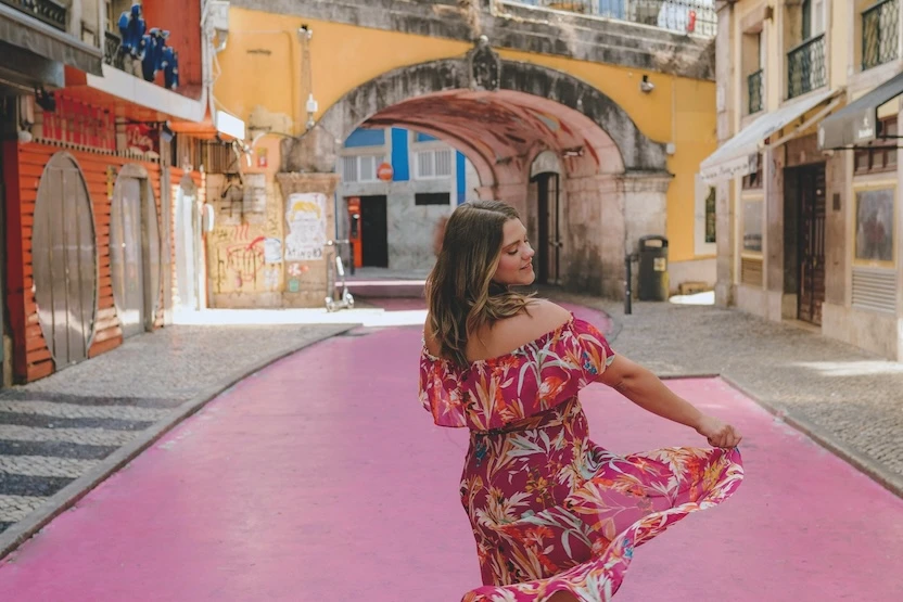 A woman in a dress, twirling in the streets of Lisbon, Portugal.