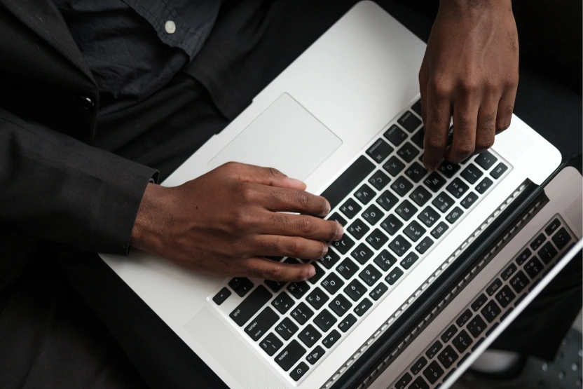 A man with a laptop on his lap, typing.