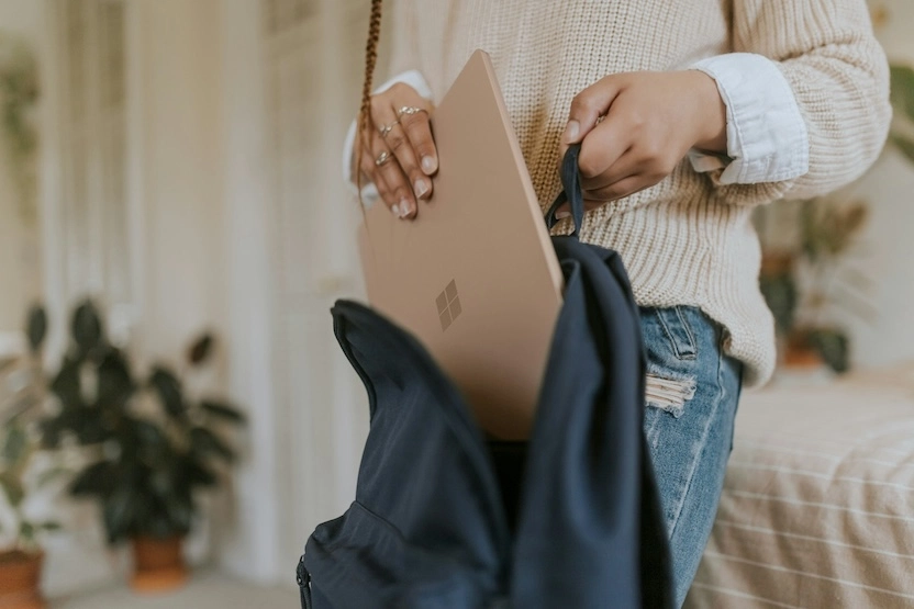 A woman packing her laptop into a bag