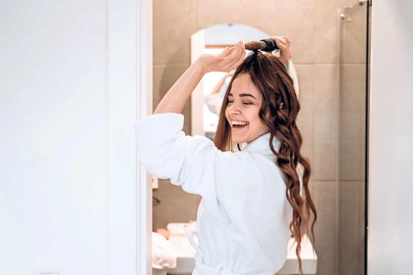 Woman curling hair in a hotel.
