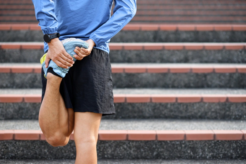 Runner in blue jacket stretching