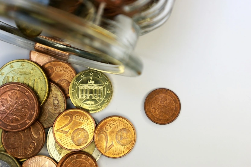 Euro coins on a table, coming out of a jar