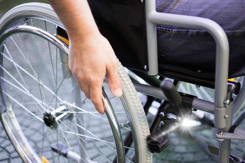 Wheelchair user, close up on wheel and hand.