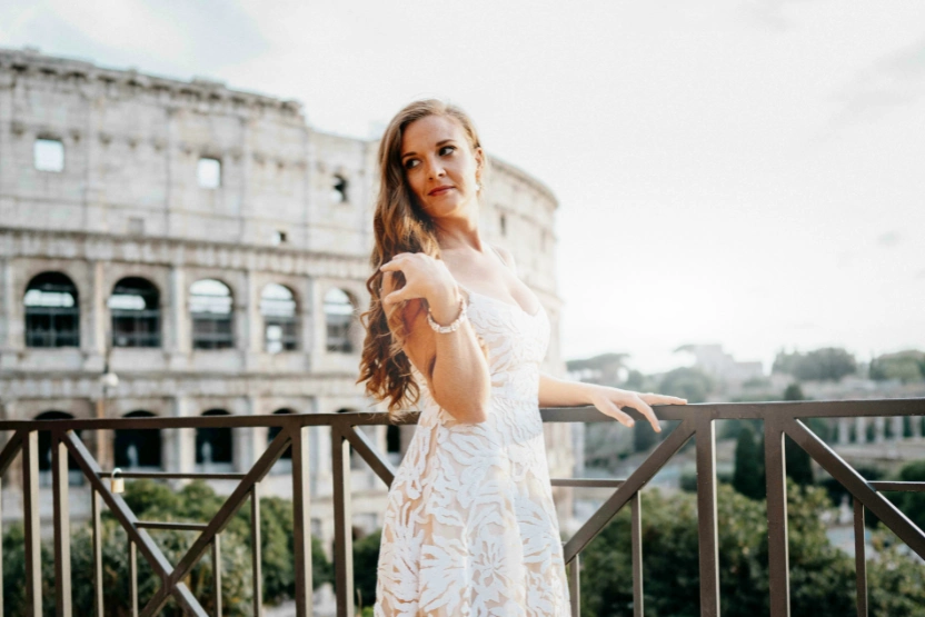 Woman posing in front of the Colosseum in Rome. 