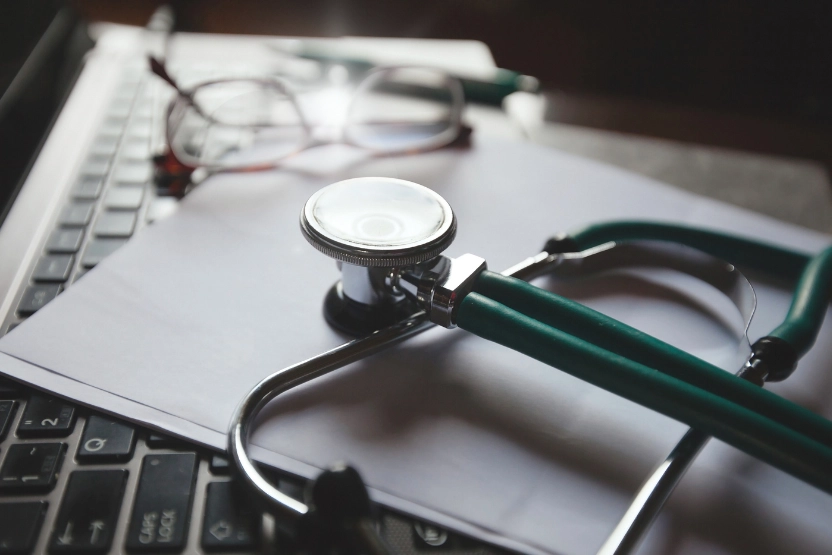Doctor's desk with stethoscope, papers, and glasses