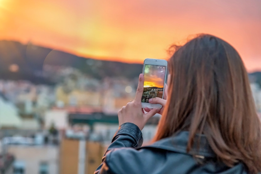 Woman taking a photo at sunset