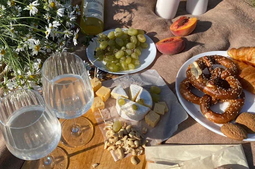 A picnic with fresh fruit, cheese, and pastries