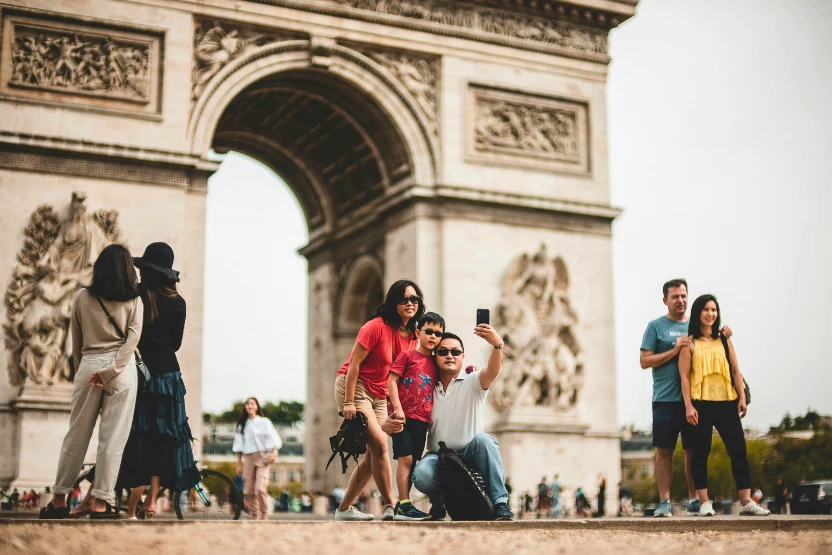 Tourists taking a photo in front of the Arc de Triomphe in Paris, France