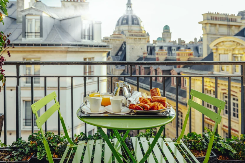 French terrace in Paris with green chairs and breakfast