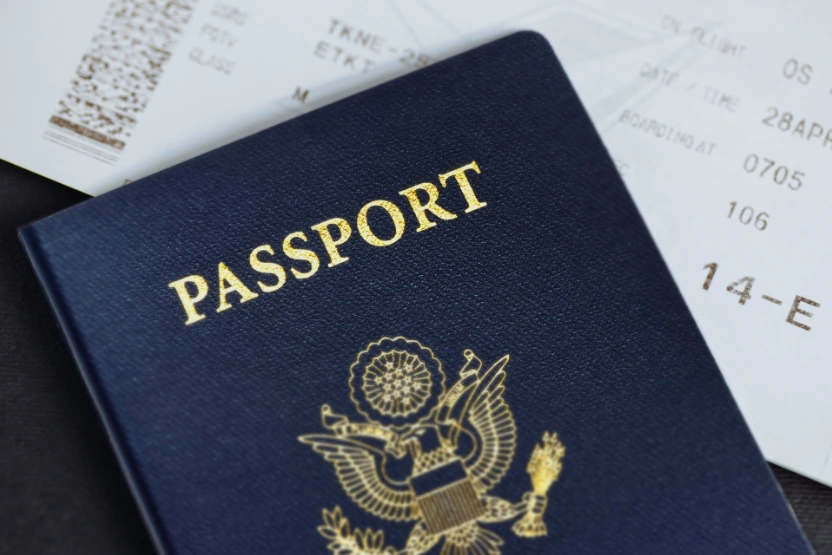 US passport sitting on top of a boarding pass